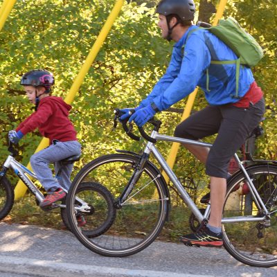 an adult and a child biking up a hill