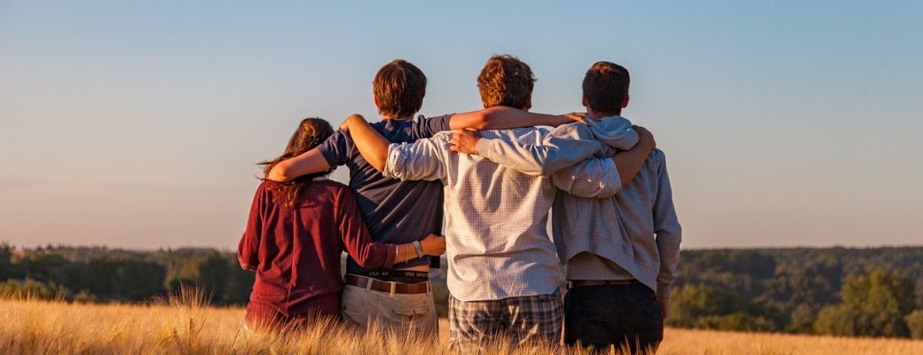 a group of 4 youths standing in a field