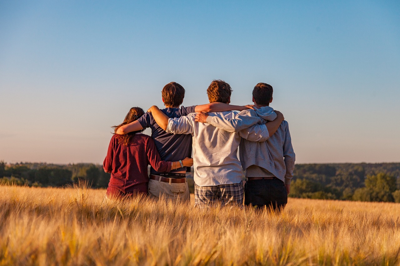 a group of 4 youths standing in a field