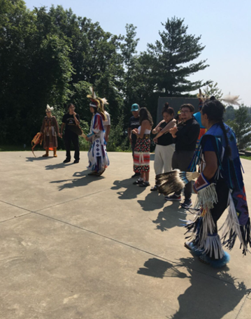 People standing in a semi-circle in traditional outfits